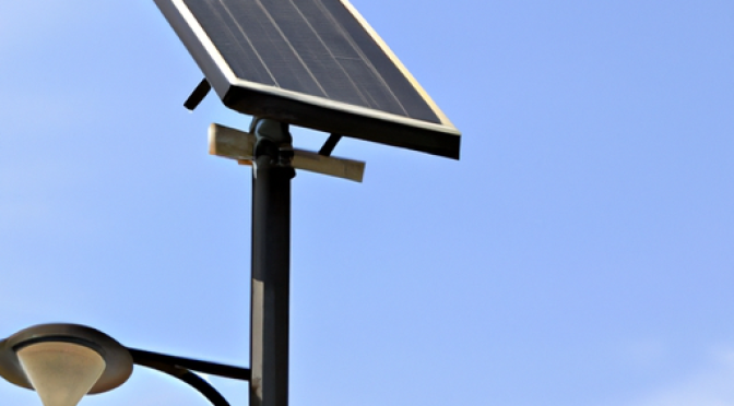 Solar-powered street lamp in city setting, photo