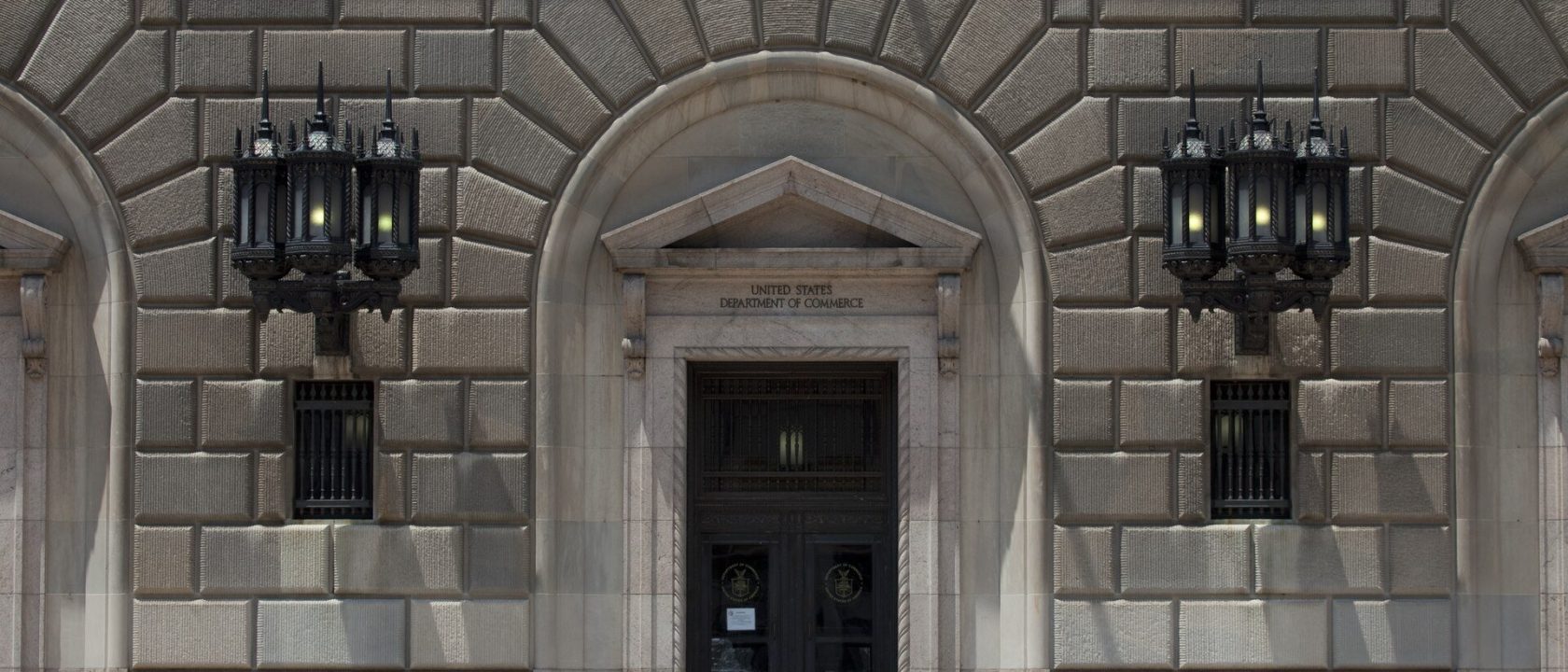 Stone facade and arched entrance of the U.S. Department of Commerce building