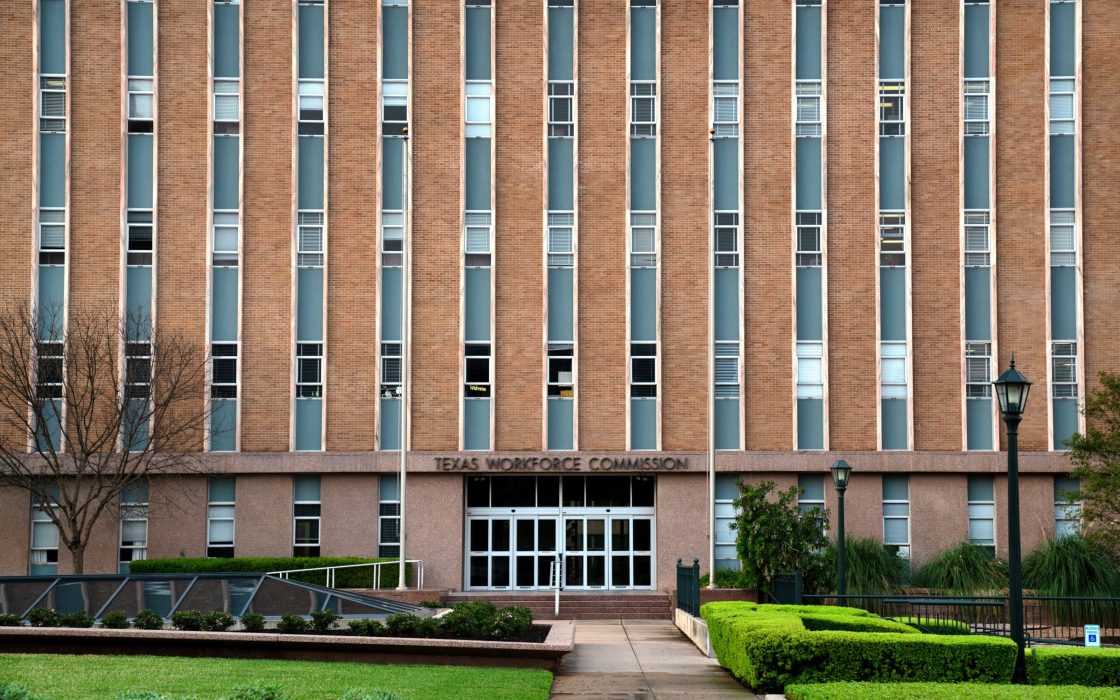 Brick facade of the Texas Workforce Commission office in Austin with landscaped entrance