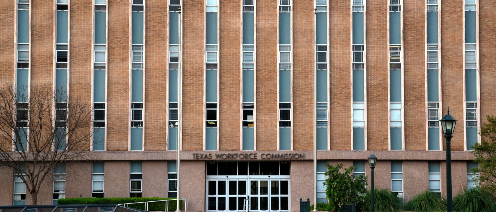 Brick facade of the Texas Workforce Commission office in Austin with landscaped entrance