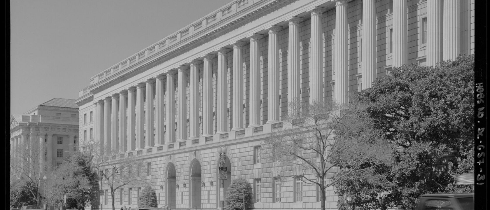 Black-and-white photo of the colonnaded IRS headquarters building along Constitution Avenue