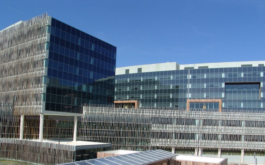 Glass and wood-slatted federal office buildings under a clear blue sky