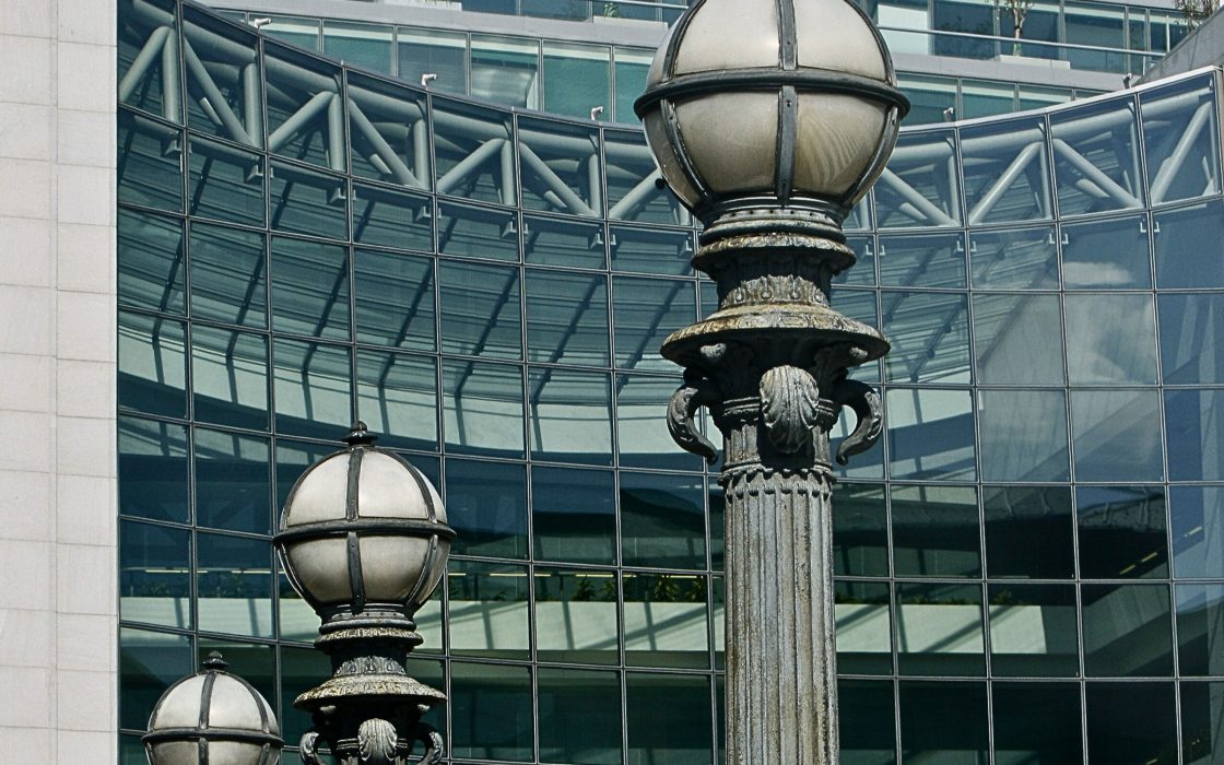 Ornate globe street lamps against the glass curtain wall of the SEC headquarters building
