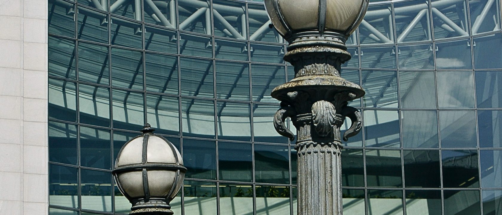 Ornate globe street lamps against the glass curtain wall of the SEC headquarters building