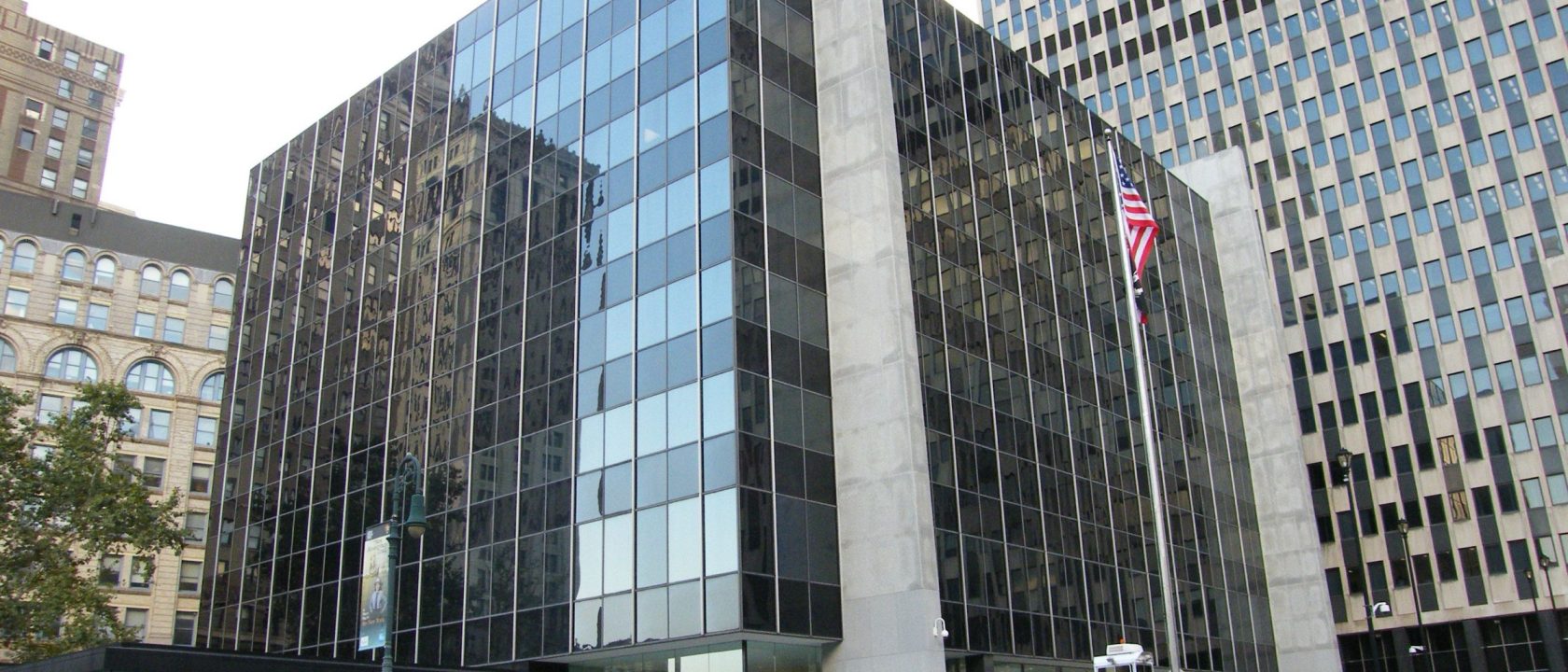 Glass-fronted Court of International Trade building in Manhattan with a US flag outside