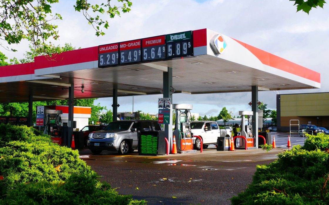 Gas station canopy with an electronic price sign showing unleaded, mid-grade, premium and diesel prices above five dollars
