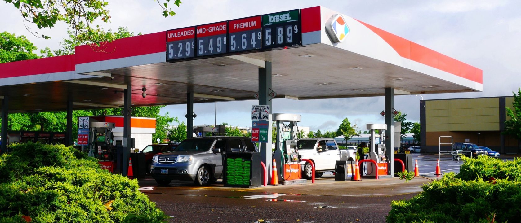 Gas station canopy with an electronic price sign showing unleaded, mid-grade, premium and diesel prices above five dollars