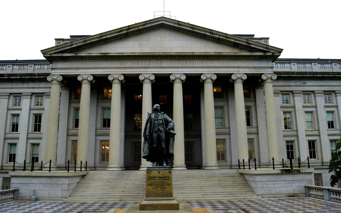 Columned facade of the U.S. Treasury Department building with a statue in front